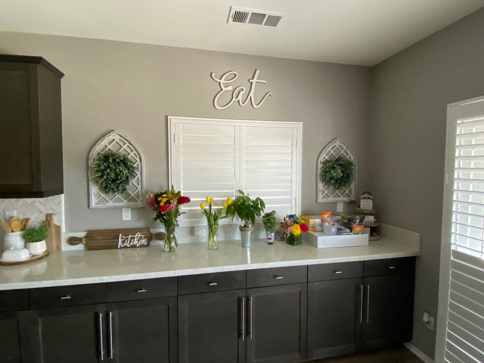 A kitchen with a sign that says eat on the wall above the counter.