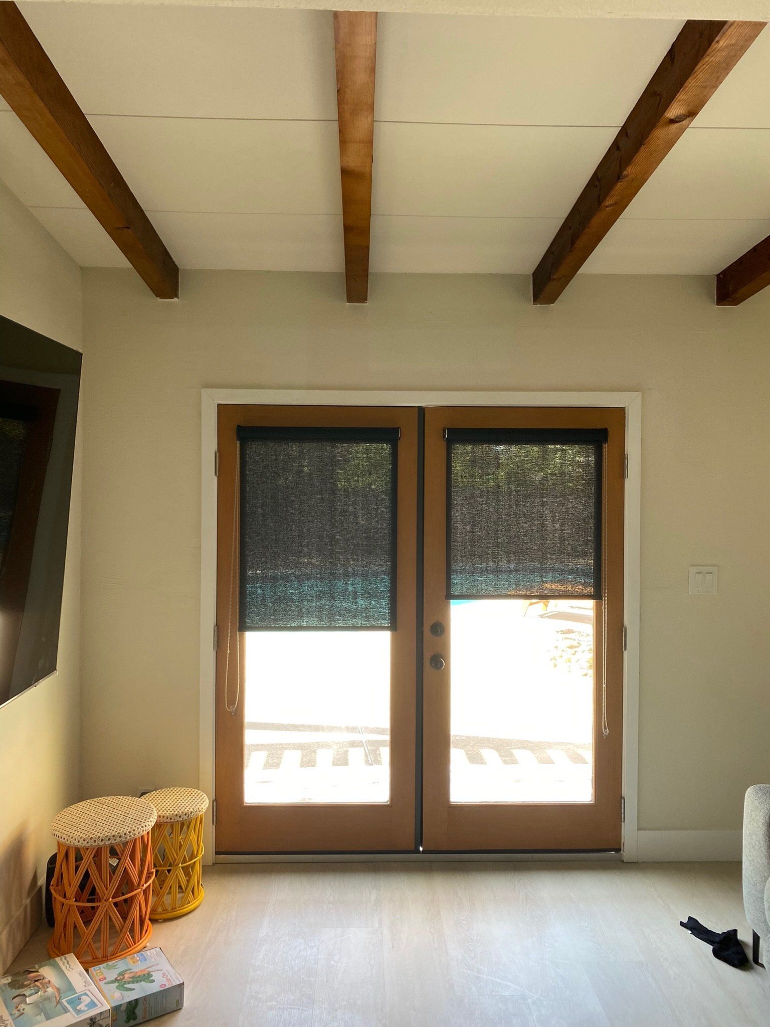A living room with a sliding glass door and wooden beams