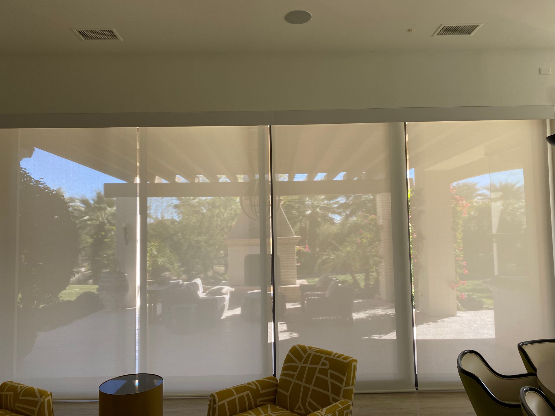 A living room with a lot of windows and chairs