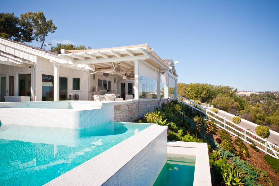 A large white house with a swimming pool in front of it