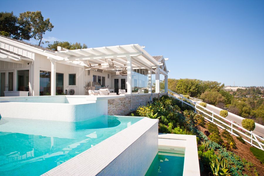 A large white house with a swimming pool in front of it