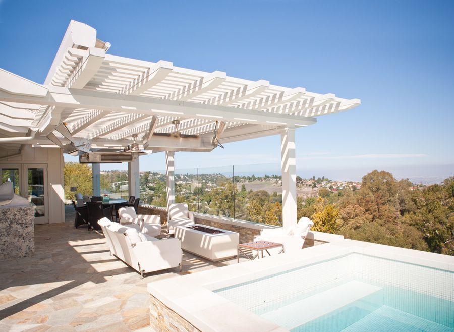 There is a swimming pool with a pergola over it.