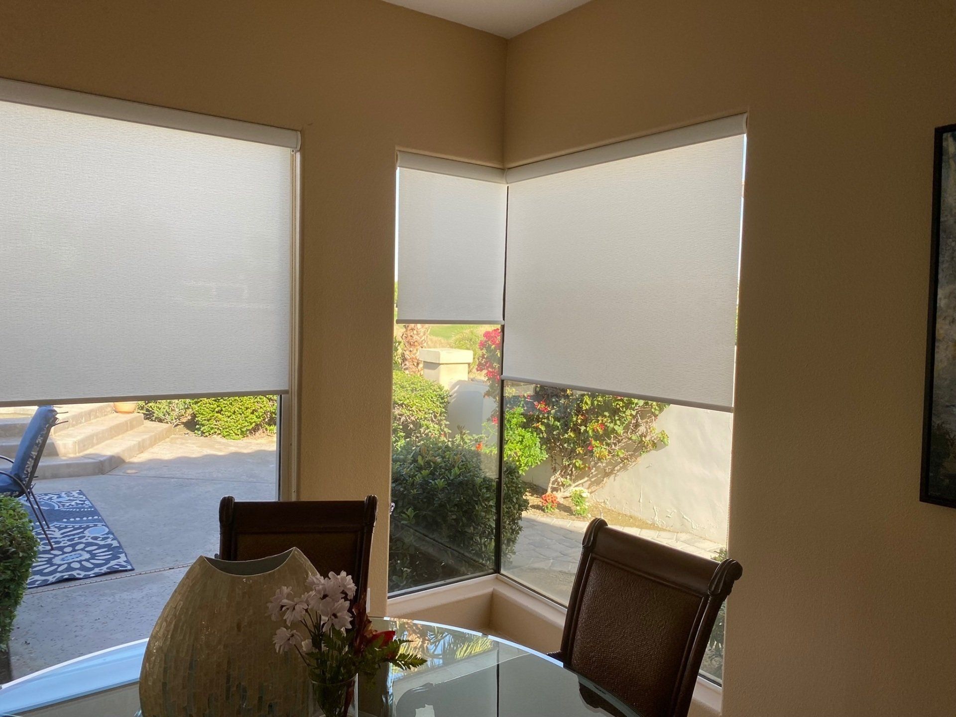 A dining room with a table and chairs and a window with blinds.