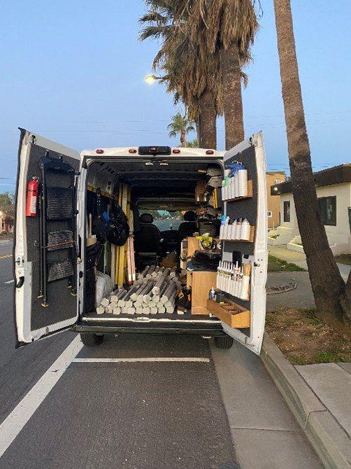 A white van is parked on the side of the road with the door open