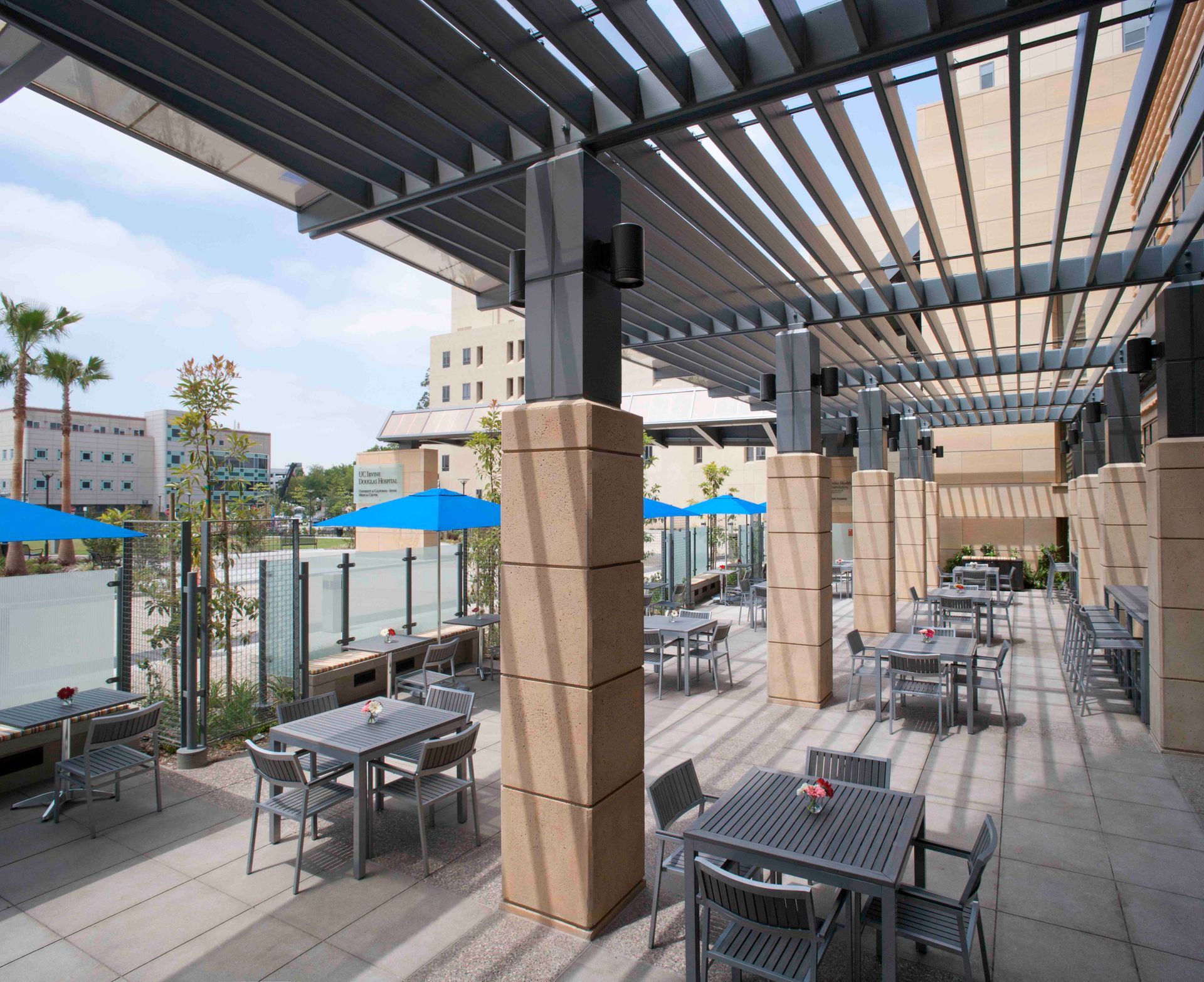 A patio with tables and chairs under a pergola