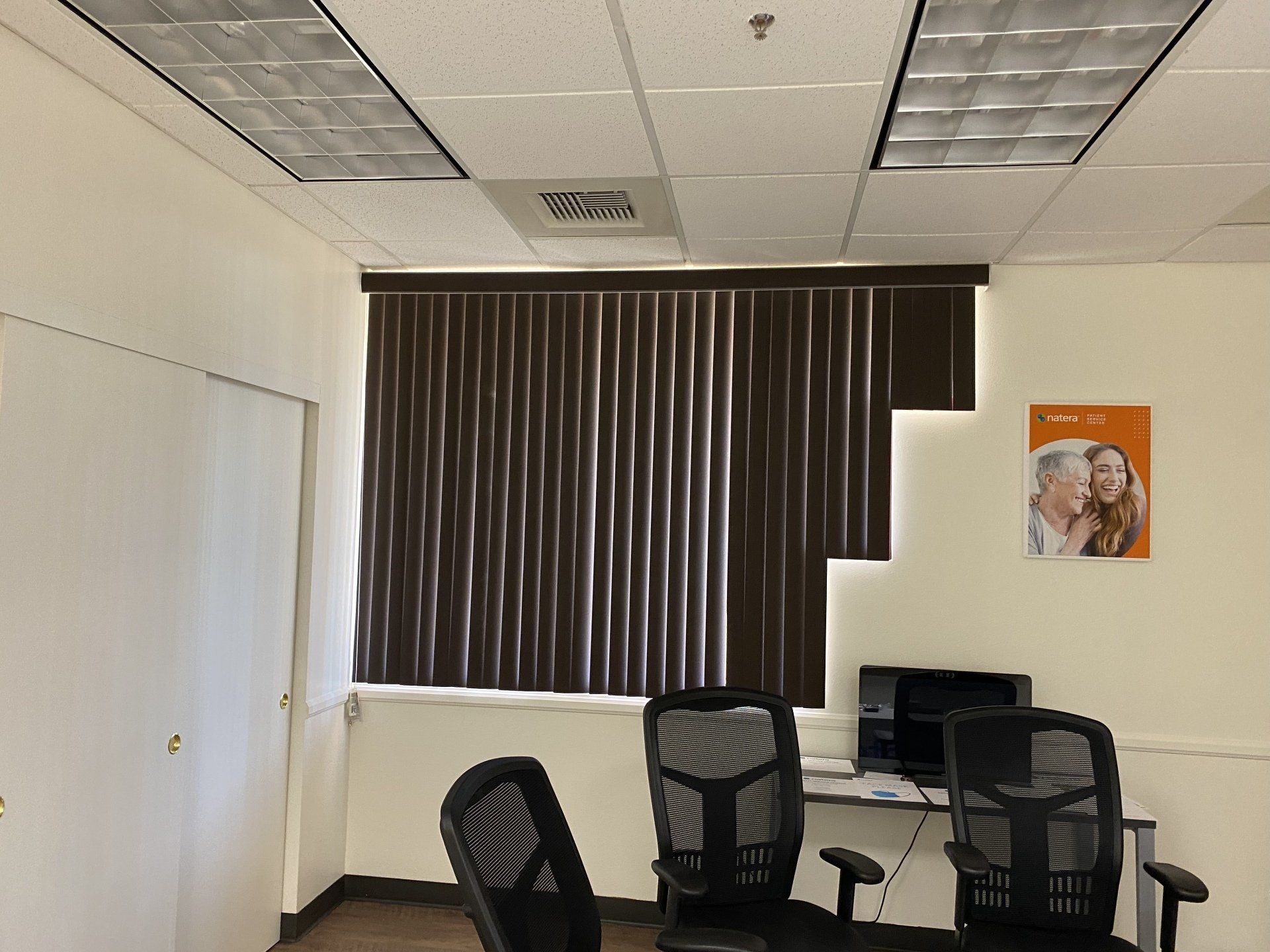 A room with two chairs a desk and a picture on the wall