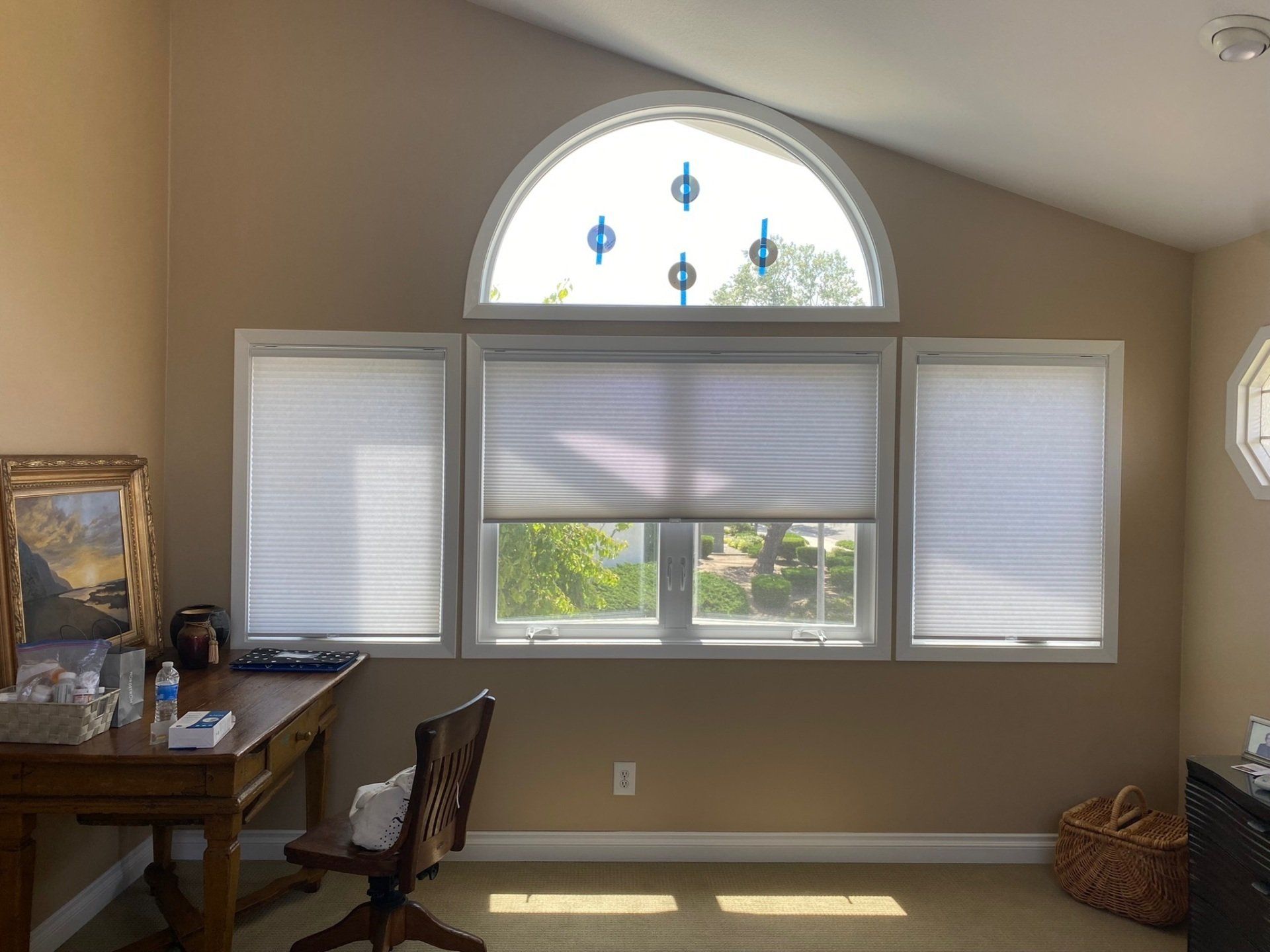 A room with a desk and chair in front of a large window.