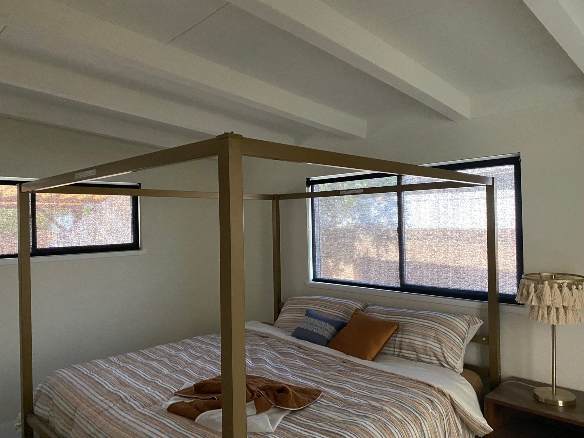 A bedroom with a canopy bed and two windows