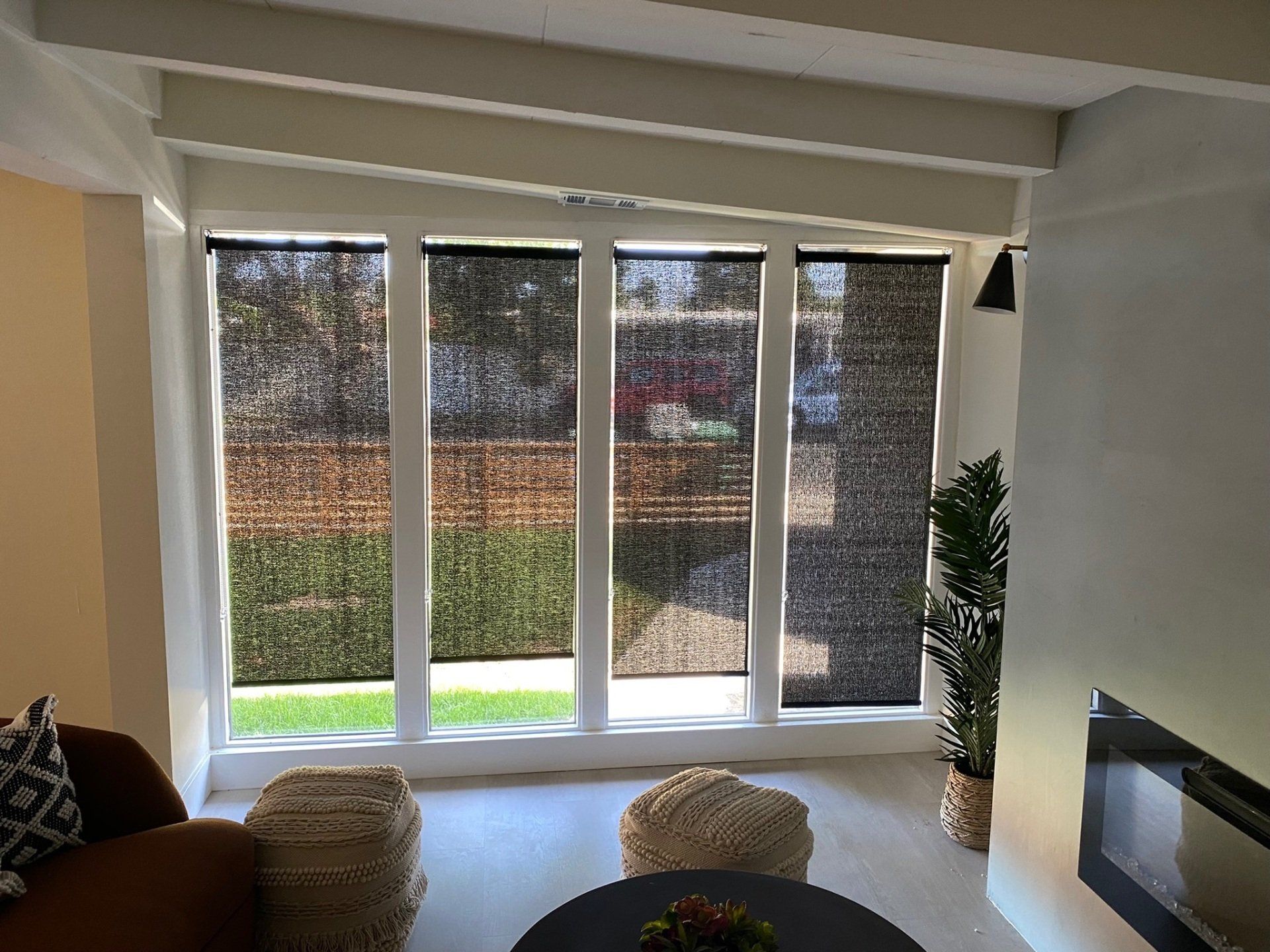 A living room with a lot of windows and a fireplace.