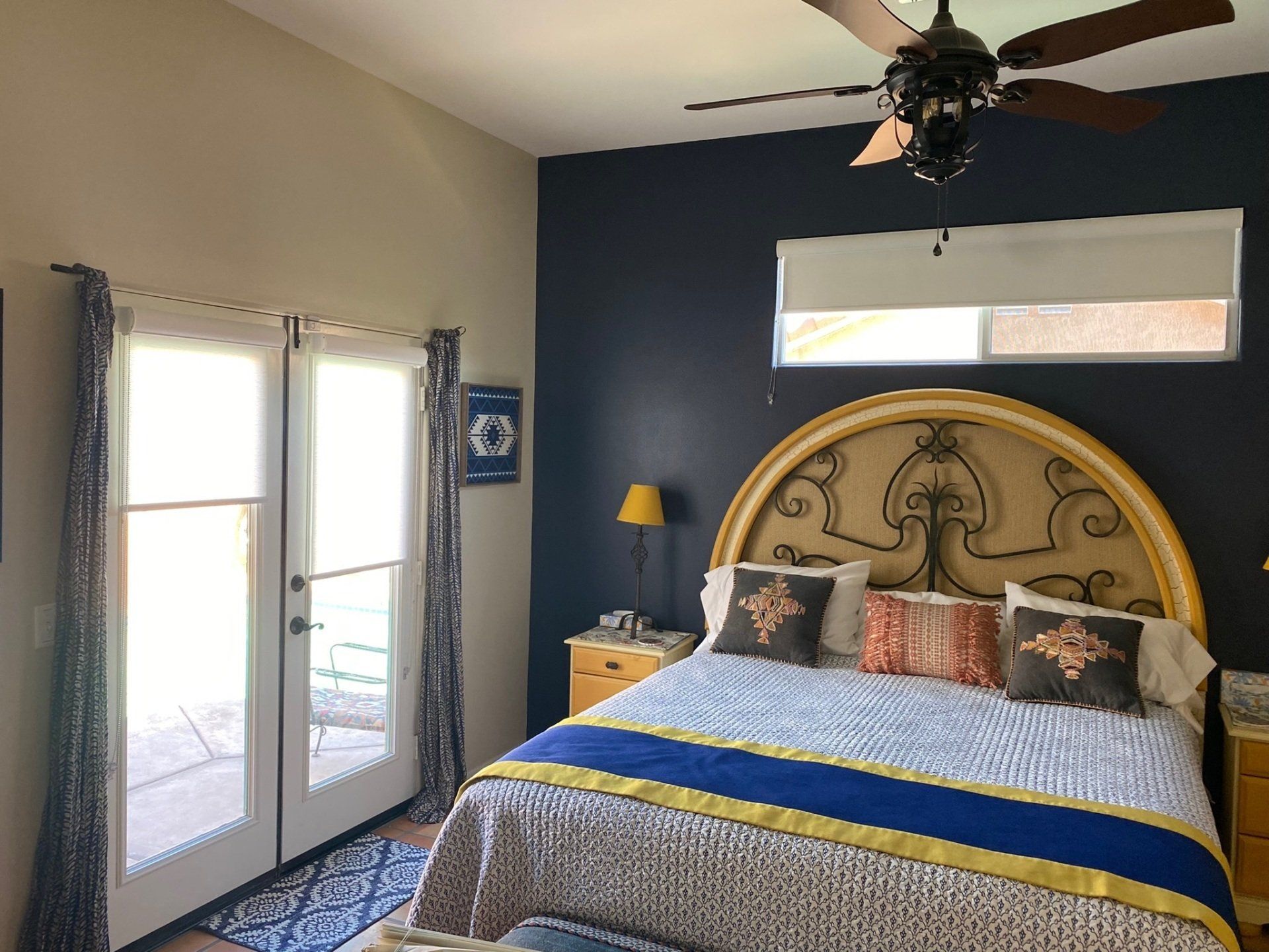 A bedroom with a bed and a ceiling fan