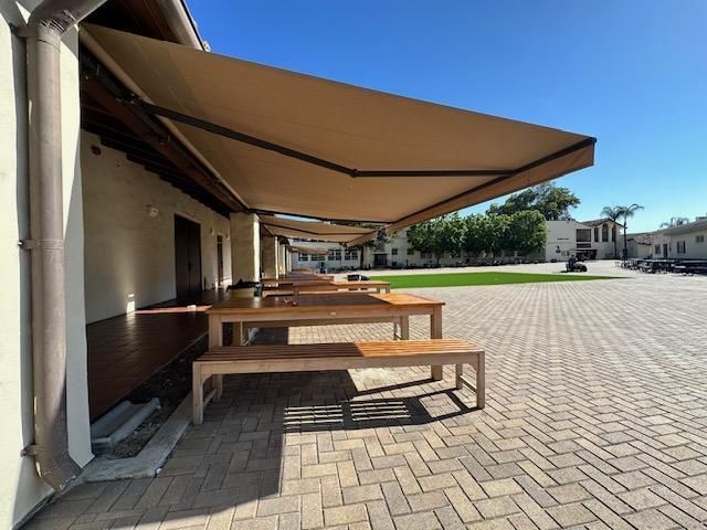 A picnic area with tables and benches under an awning