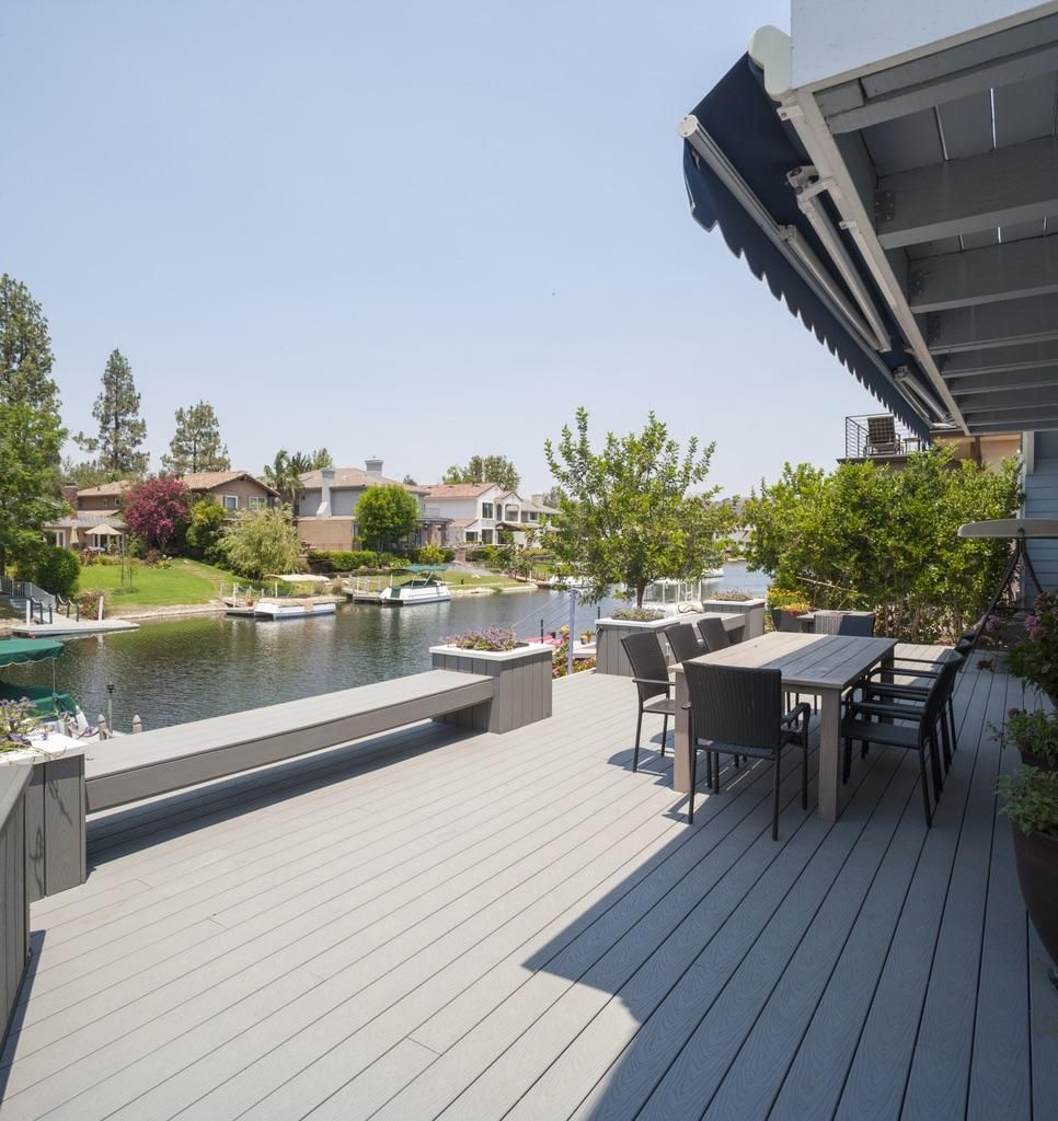 A deck with a table and chairs overlooking a body of water