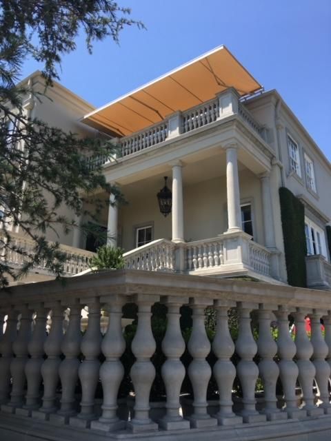 A large white house with a balcony and an awning