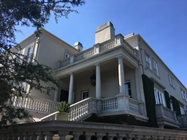 A large white house with a balcony and stairs