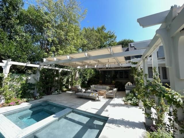 A large swimming pool with a pergola over it