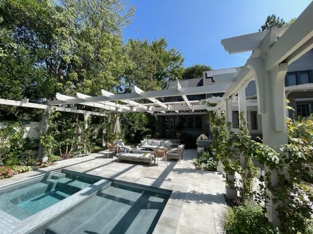 A large swimming pool with a pergola over it