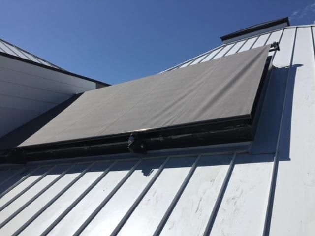 A white roof with a gray awning on it