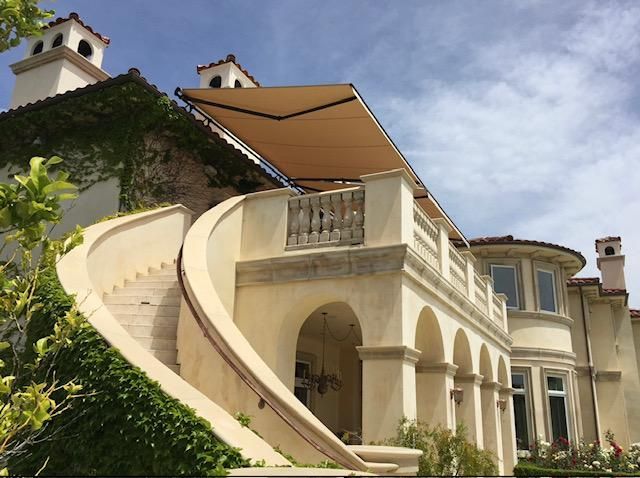 A large house with a balcony and an awning over it.