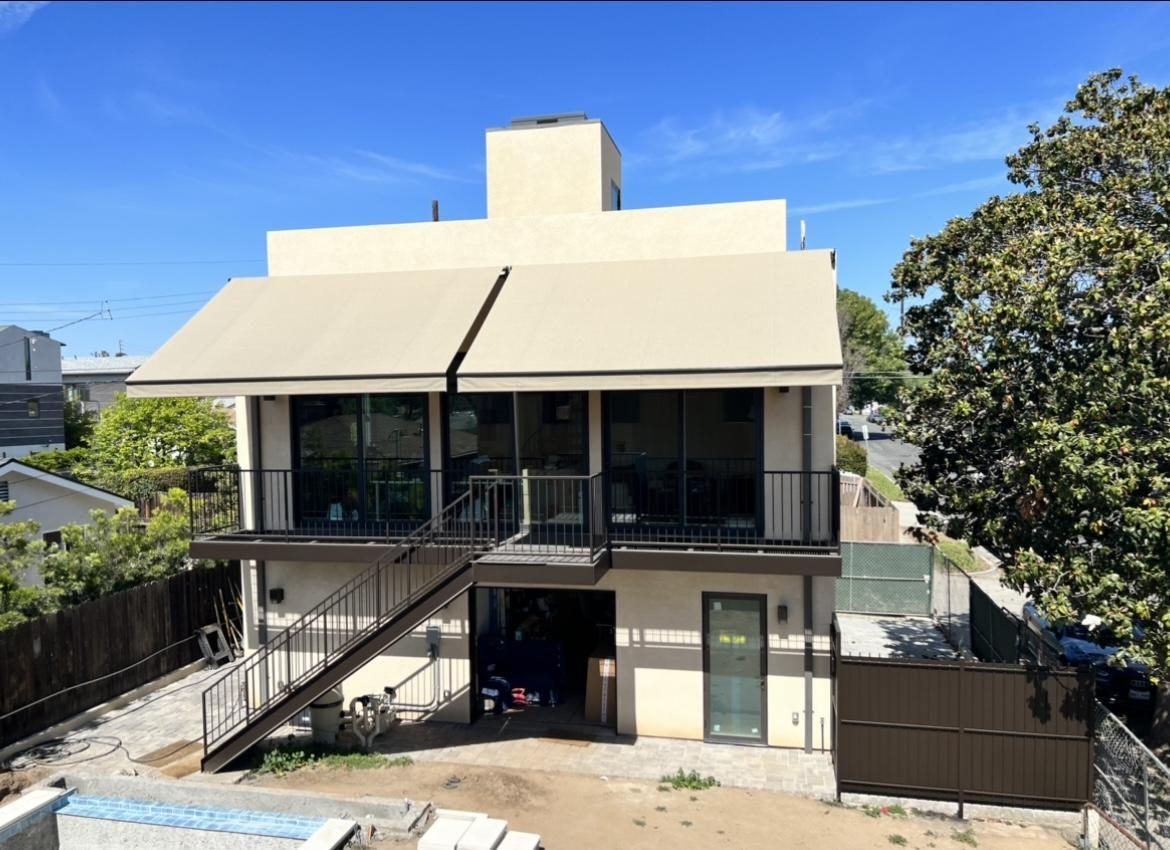 The back of a house with stairs leading up to the second floor.