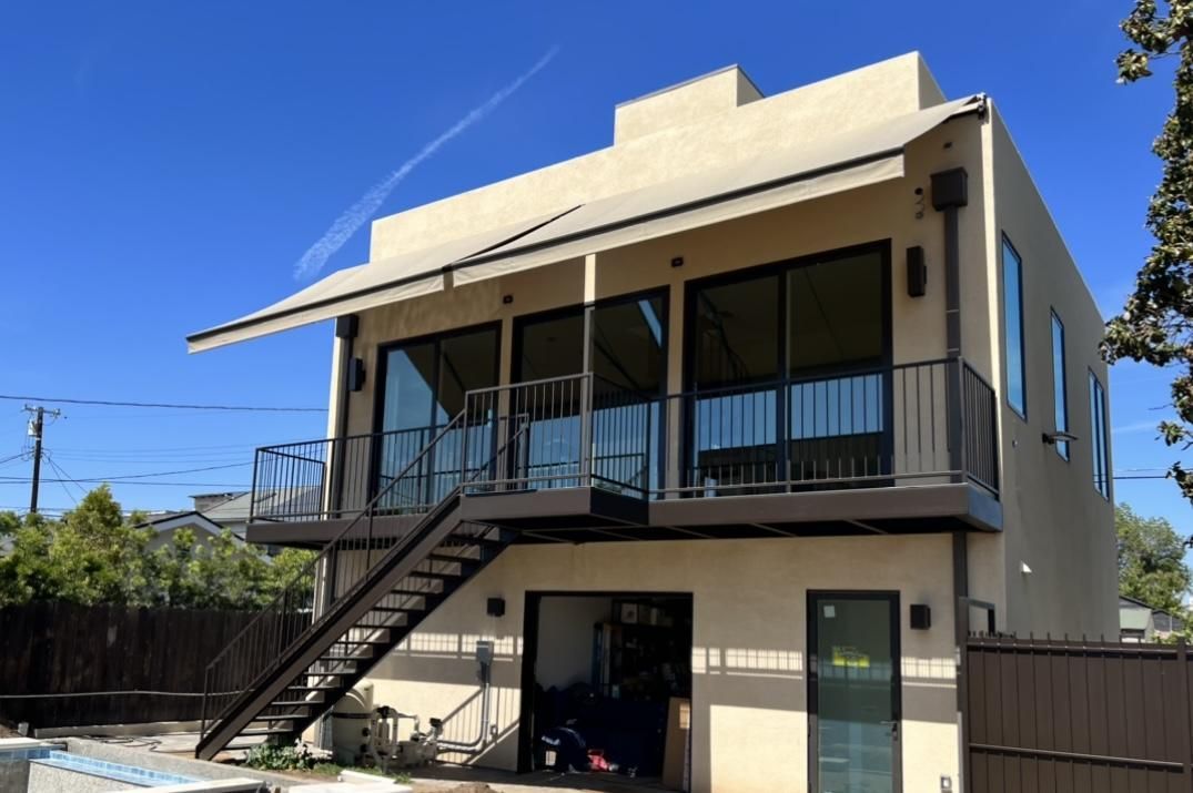 A house with a balcony and stairs on the side of it.