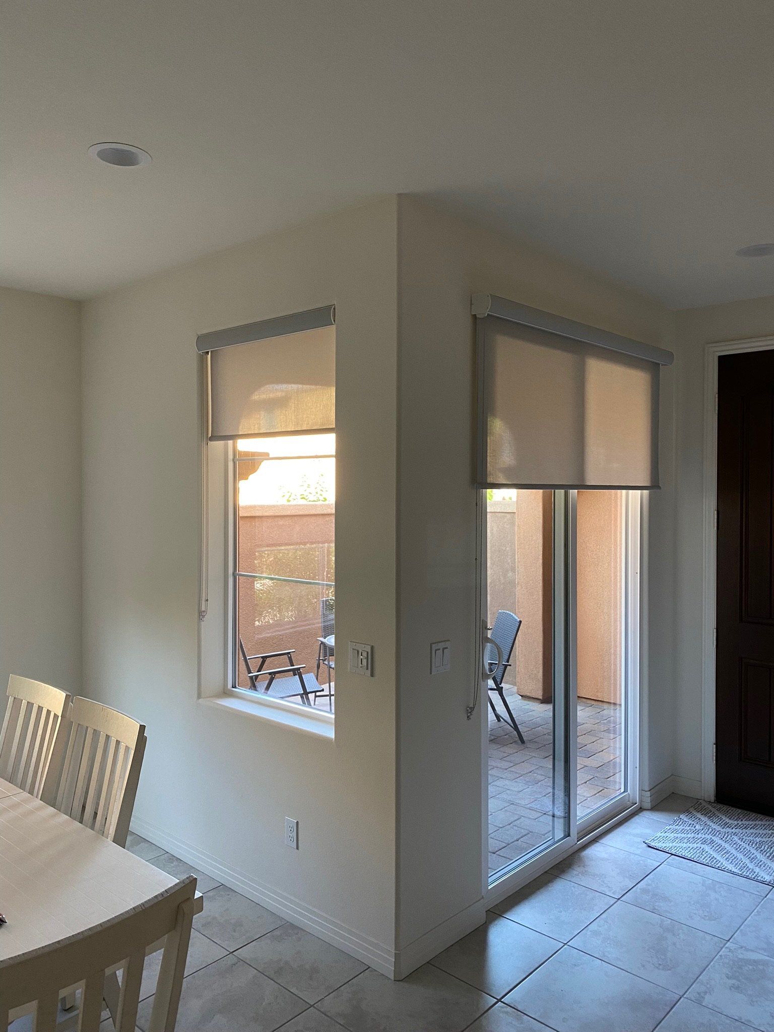 A dining room with a table and chairs and a sliding glass door leading to a patio.