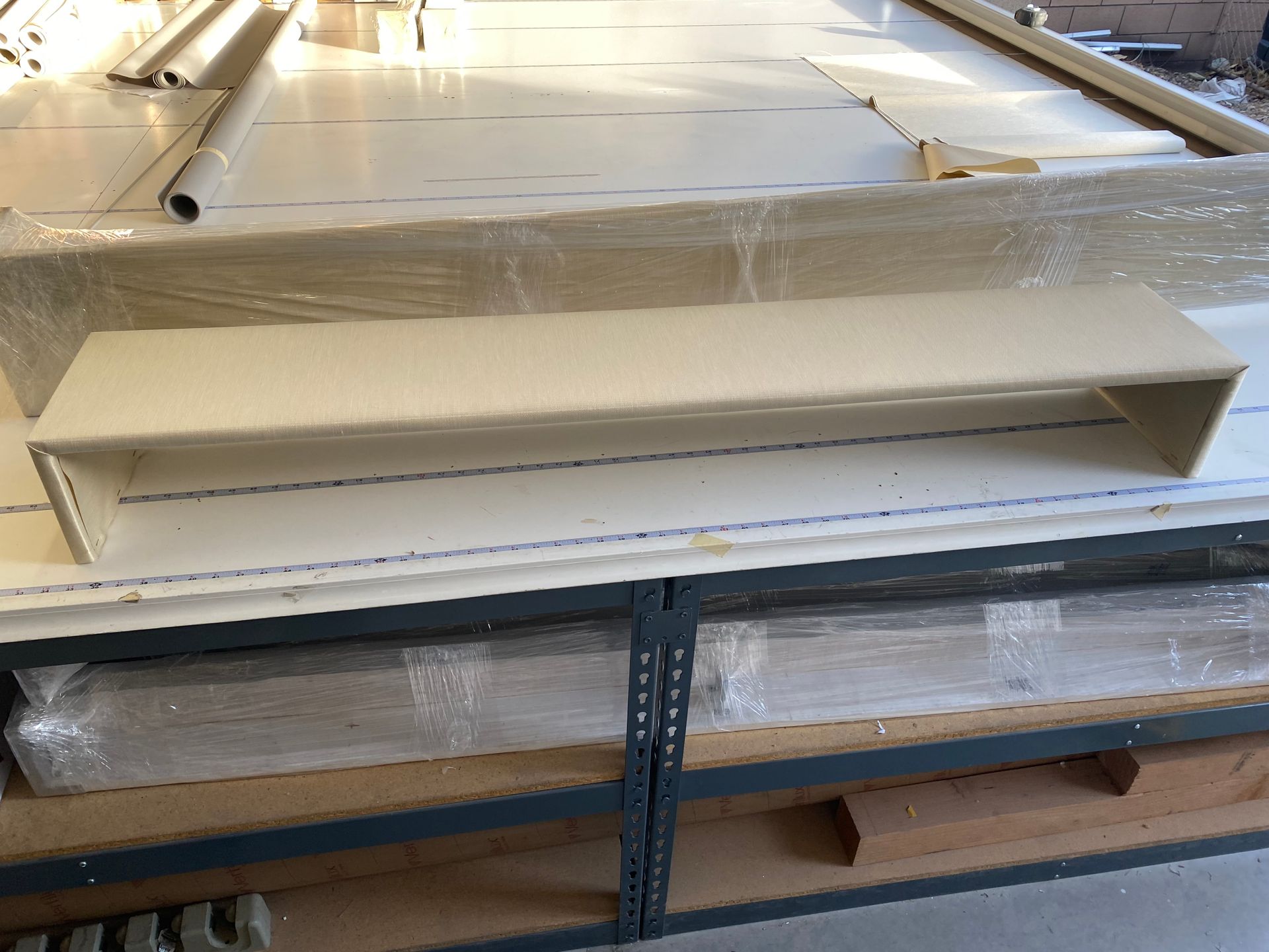 A white shelf is sitting on top of a wooden shelf.