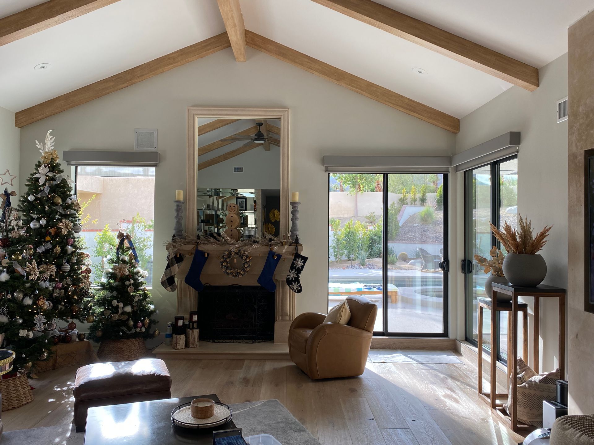 A living room with a christmas tree and a fireplace.