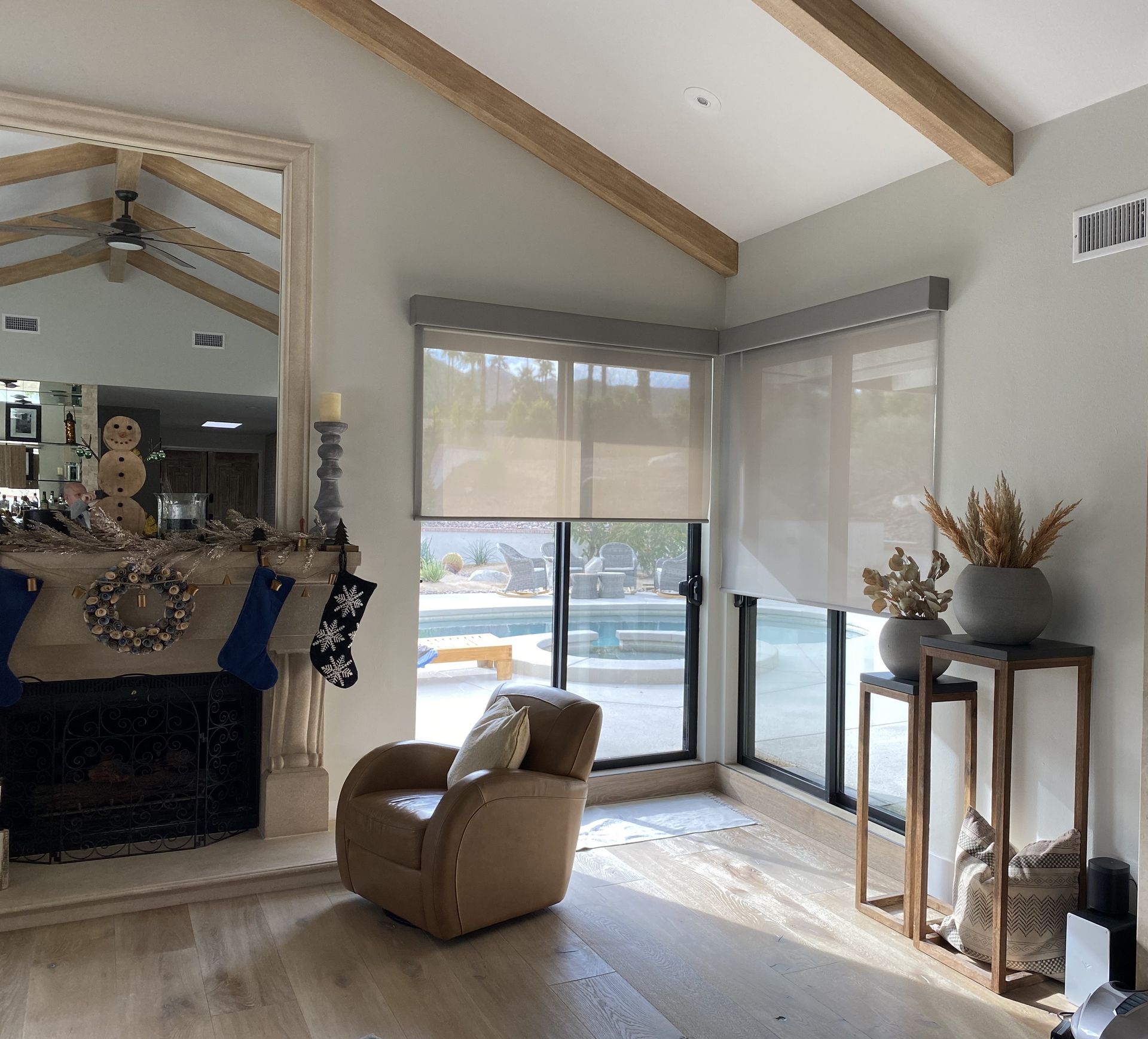 A living room with a chair a fireplace and a large mirror