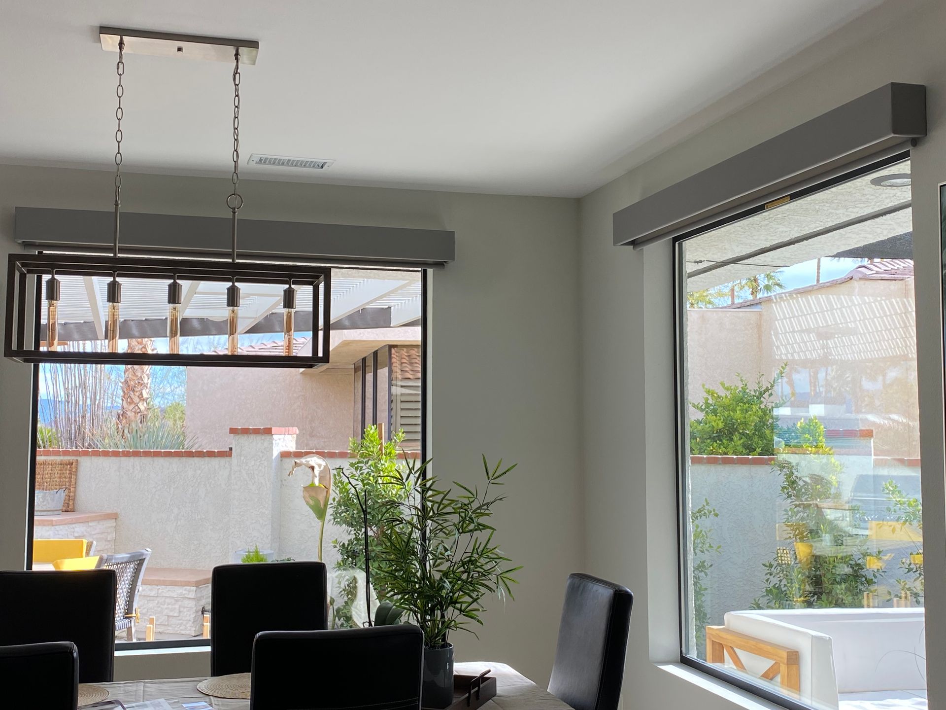 A dining room with a table and chairs and a large window