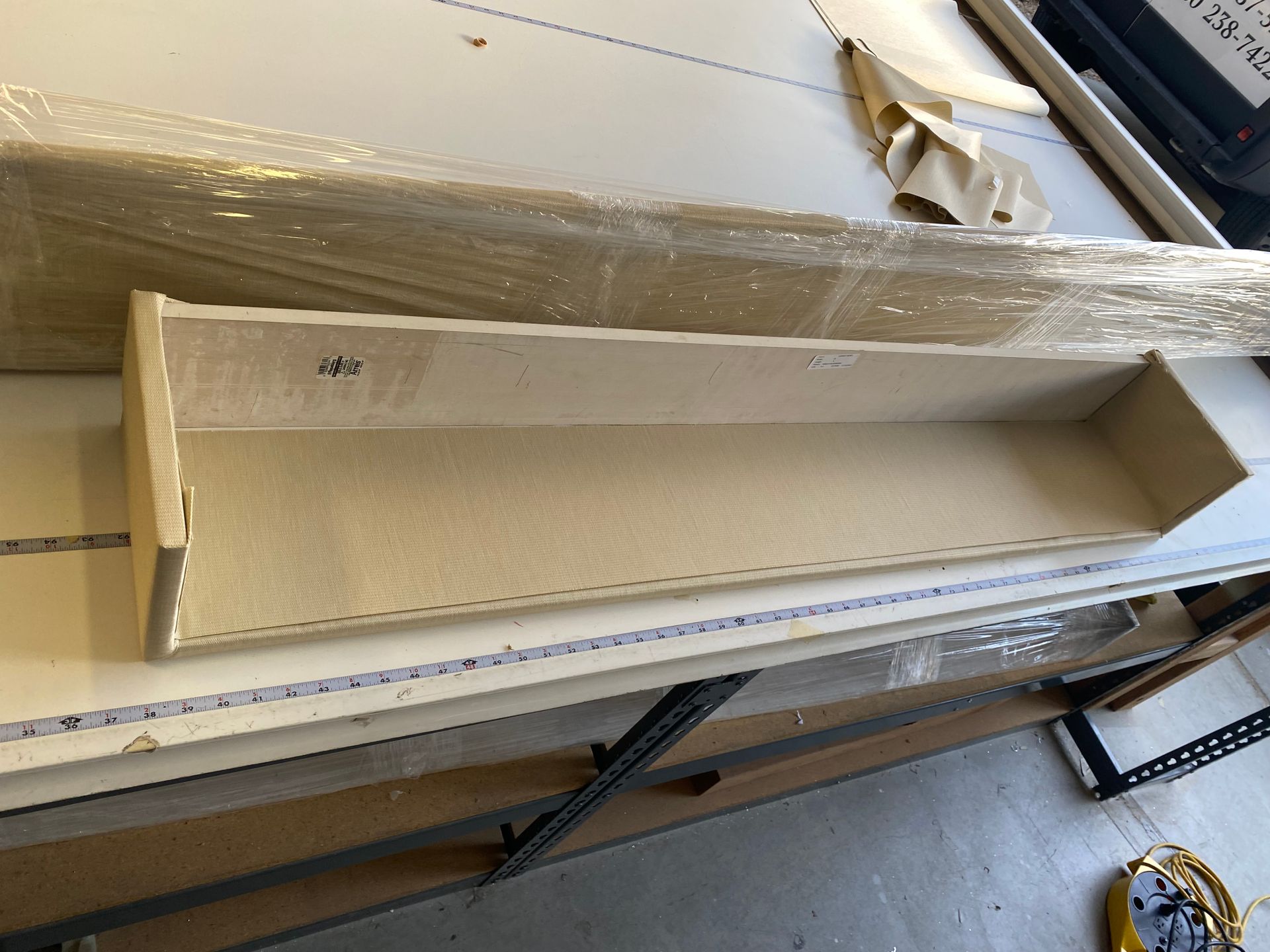 A wooden shelf is sitting on top of a white table.