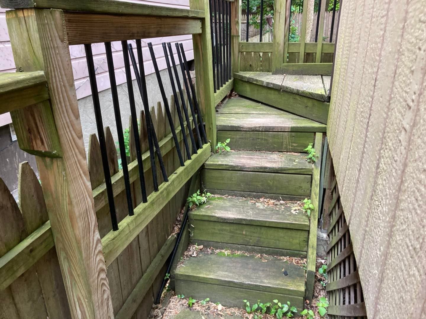 A wooden deck with stairs leading up to it and a fence.