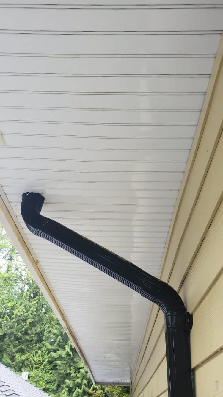 A black gutter is attached to the side of a house.
