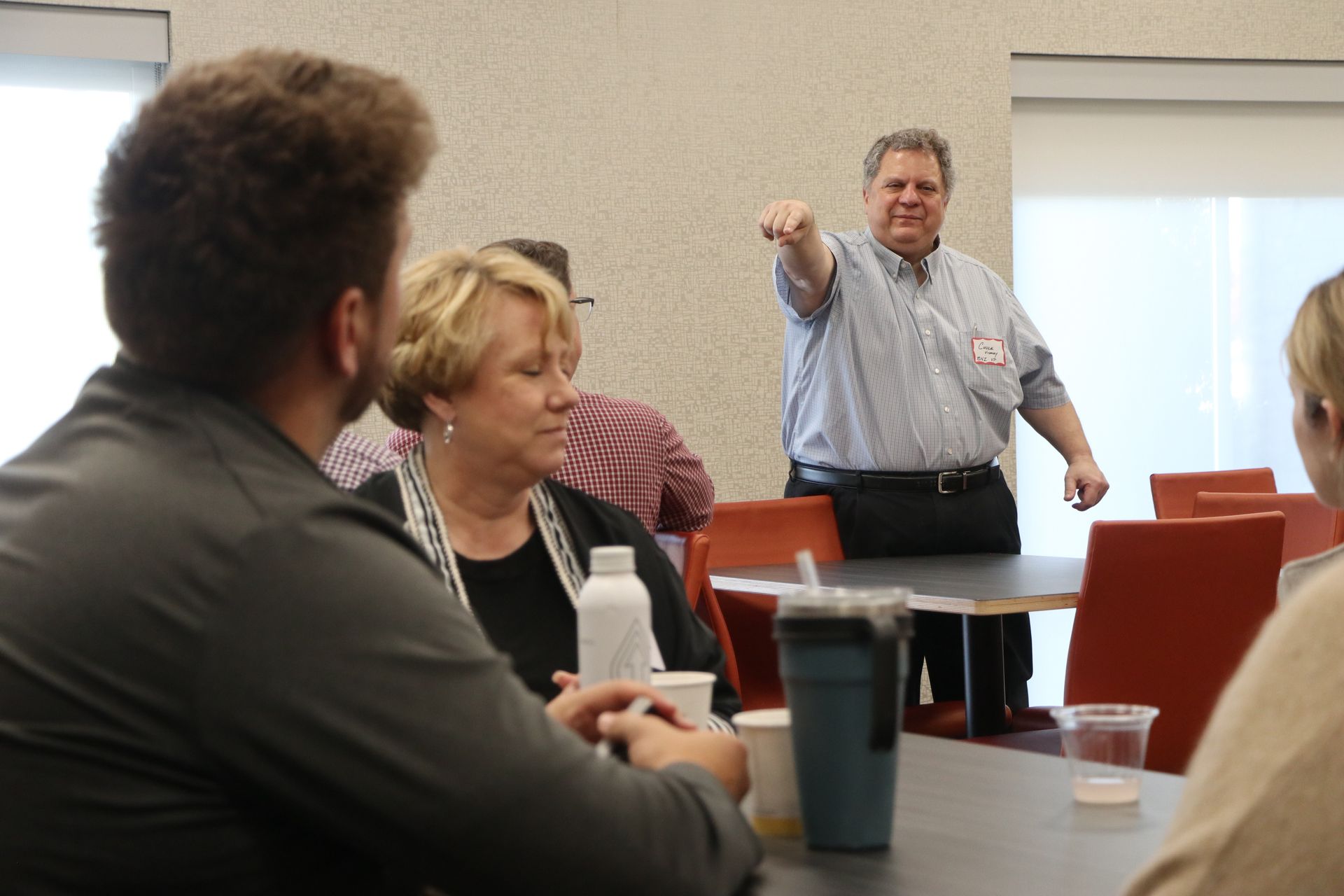 A man is giving a presentation to a group of people at a table.