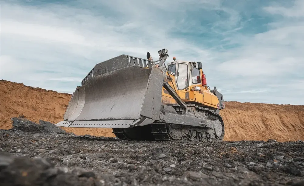Yellow bulldozer pushing a pile of dirt and rocks on a sunny day — Shantui QLD in Kingsthorpe, QLD