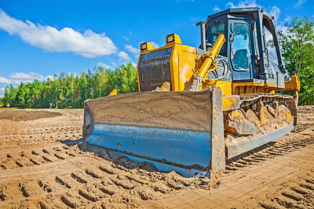 Yellow Bulldozer with A Blue Blade Leveling Earth on A Construction Site — Shantui QLD in Kingsthorpe, QLD