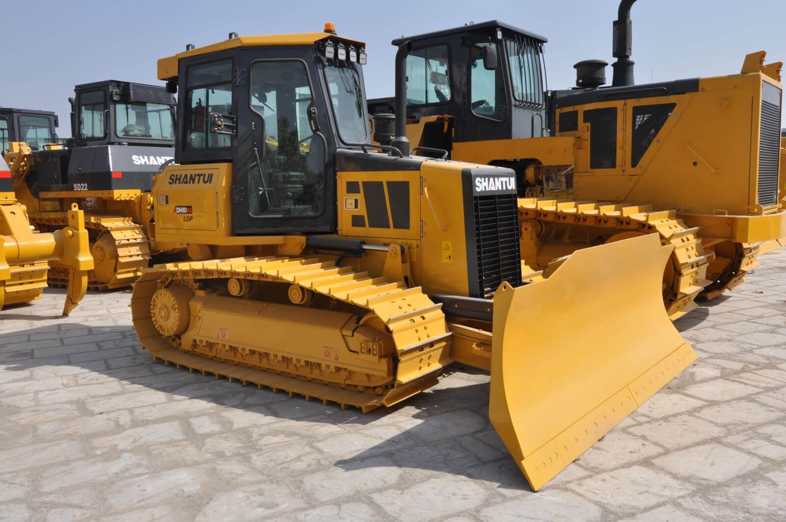 A bulldozer, yellow, grading soil on a construction site 