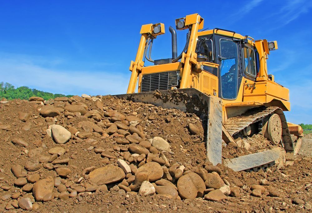 Yellow bulldozer pushing a pile of dirt and rocks on a sunny day — Shantui QLD in Kingsthorpe, QLD