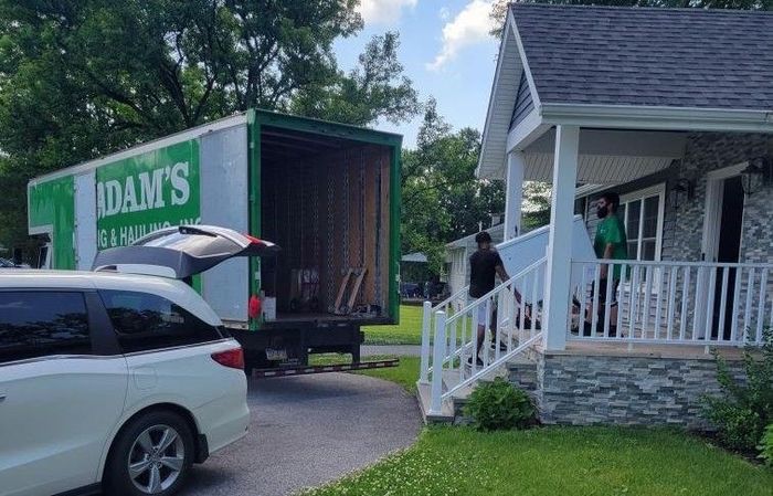 A moving truck is parked in front of a house.