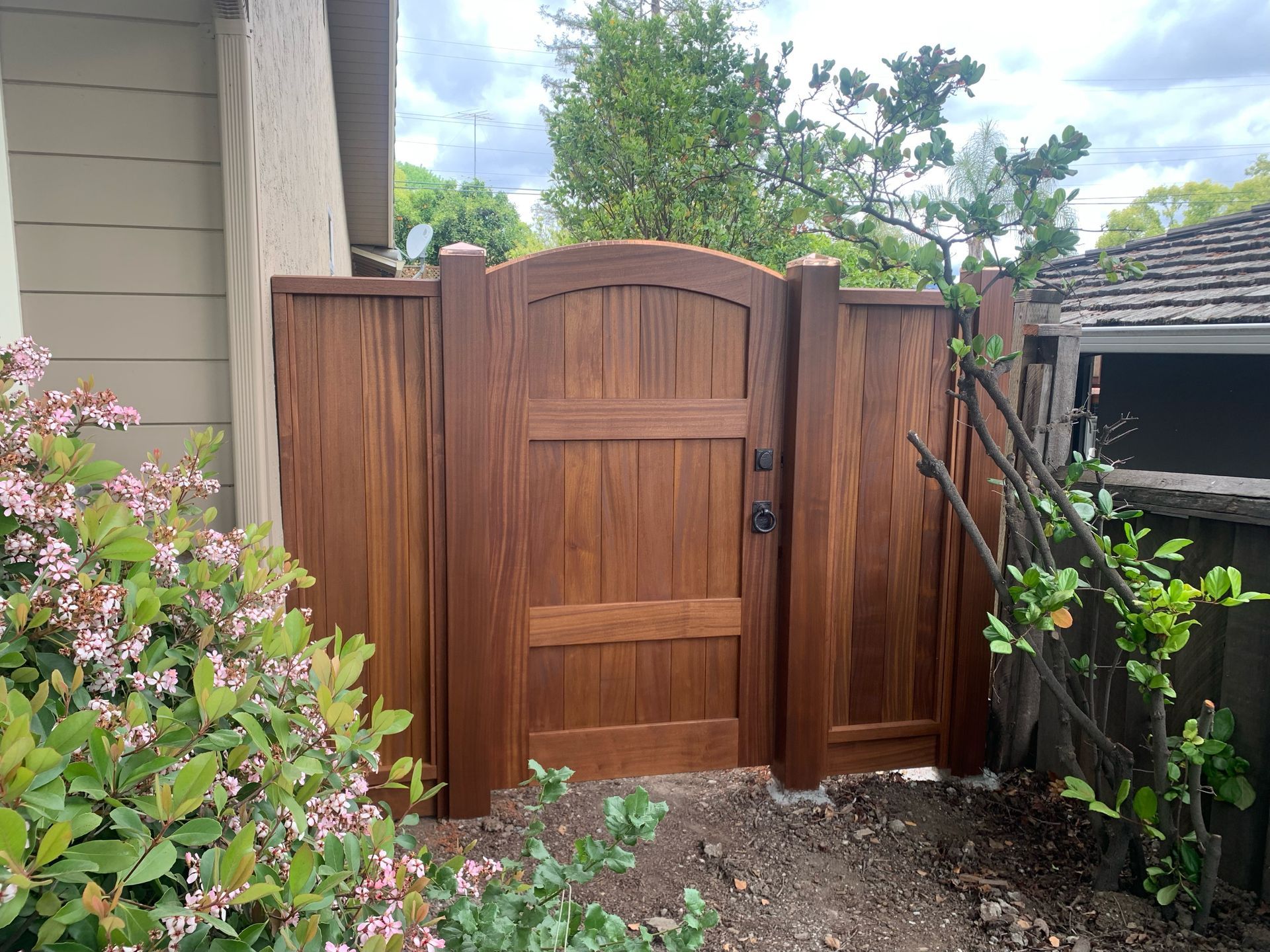 A wooden gate is sitting in front of a house.