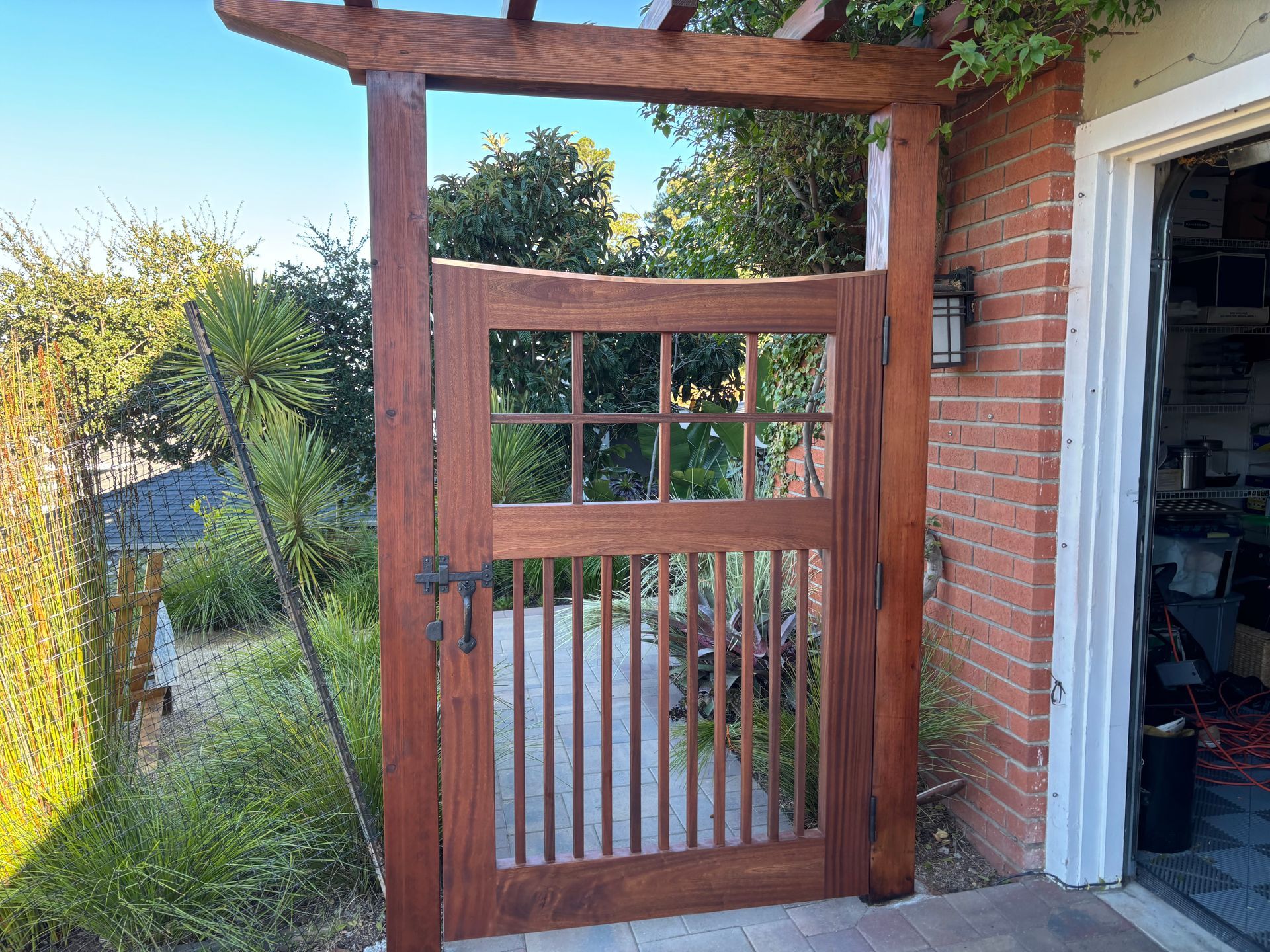 A wooden gate is sitting in front of a brick building.