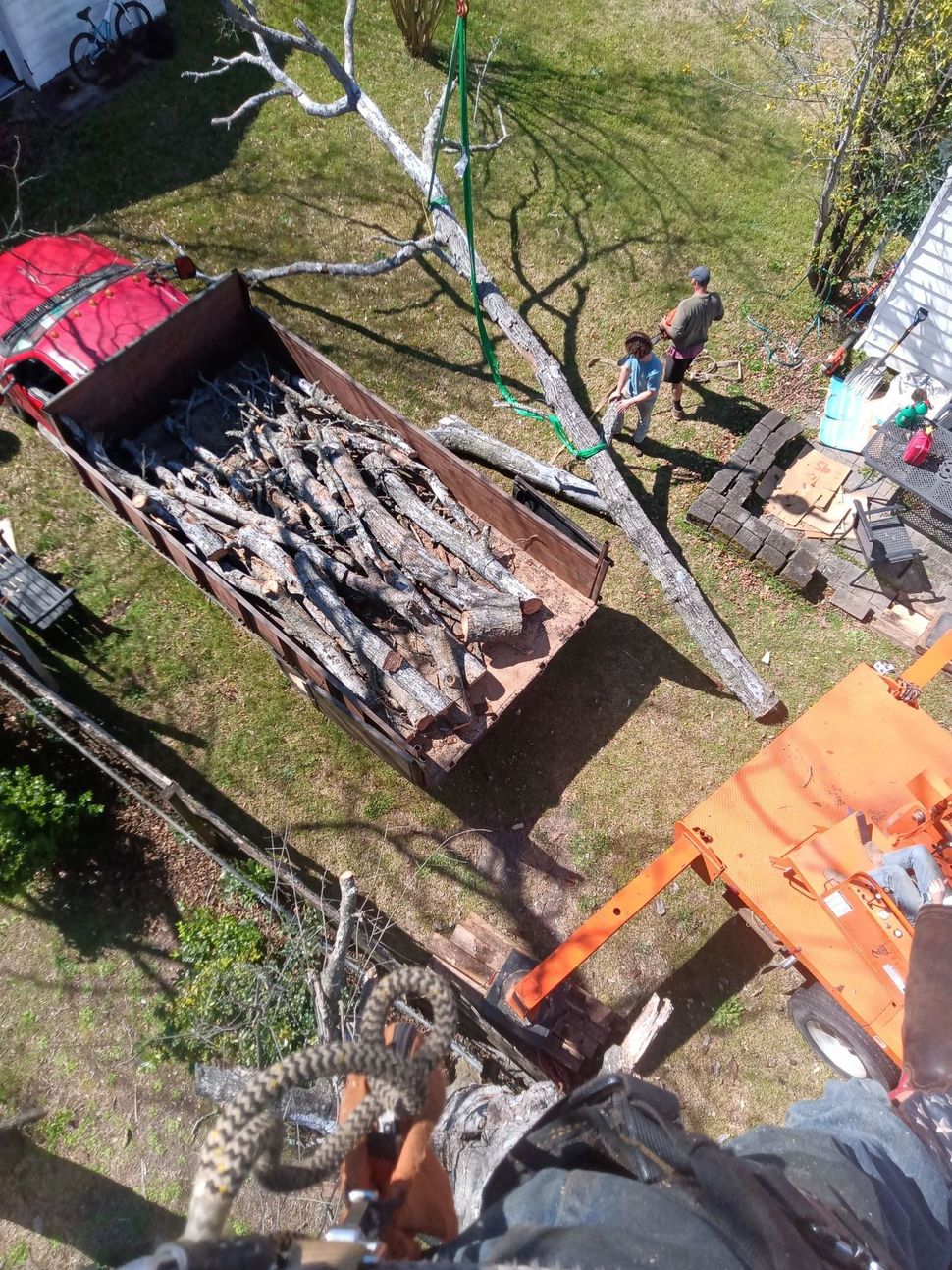 An aerial view of a truck filled with logs in a yard.