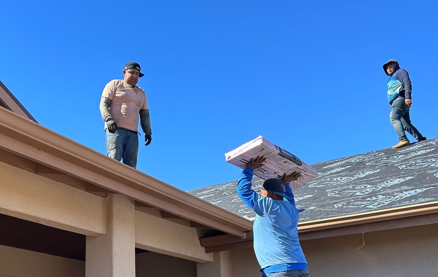 Two men are working on the roof of a house