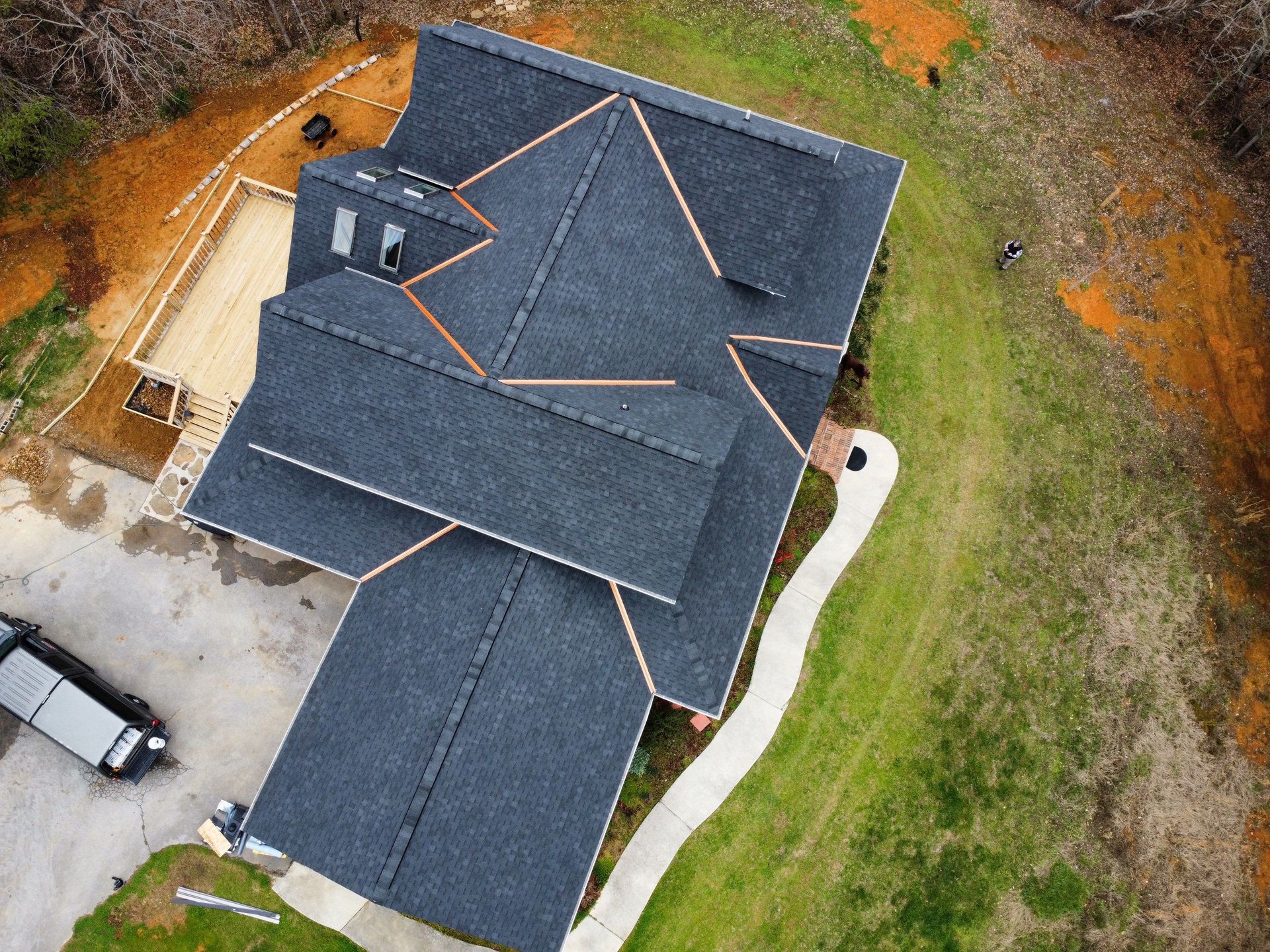 An aerial view of a house under construction with a black roof.