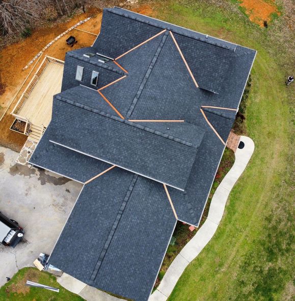 An aerial view of a house with a new roof being installed.