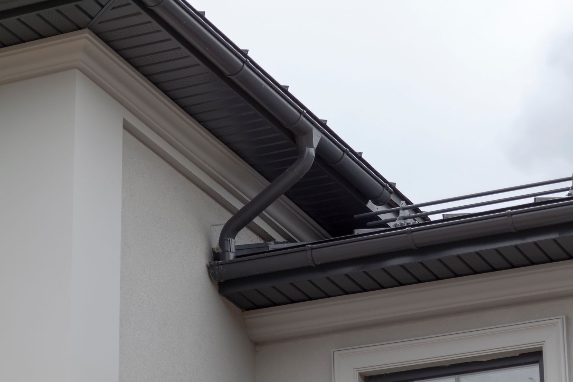 A close up of a gutter on the side of a building