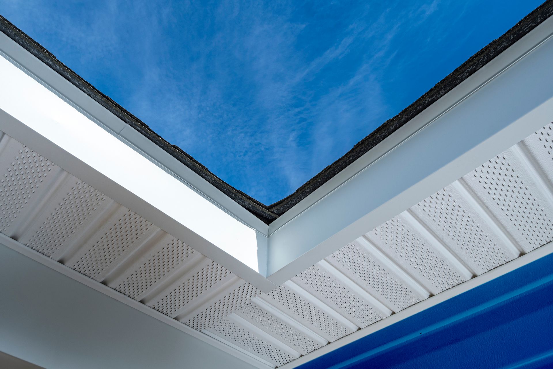 The roof of a house with a blue sky in the background.