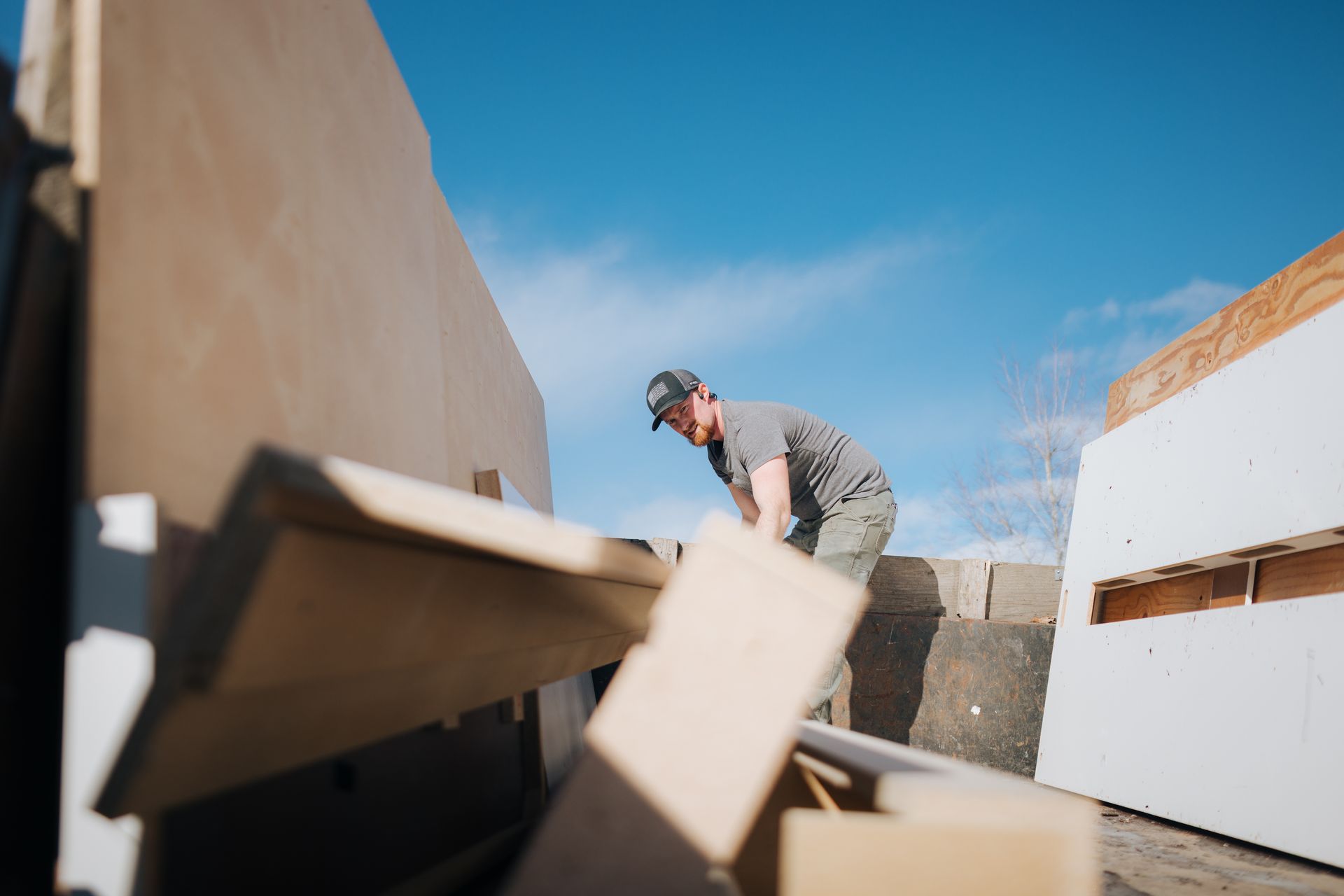 A man is standing on top of a pile of cardboard boxes.