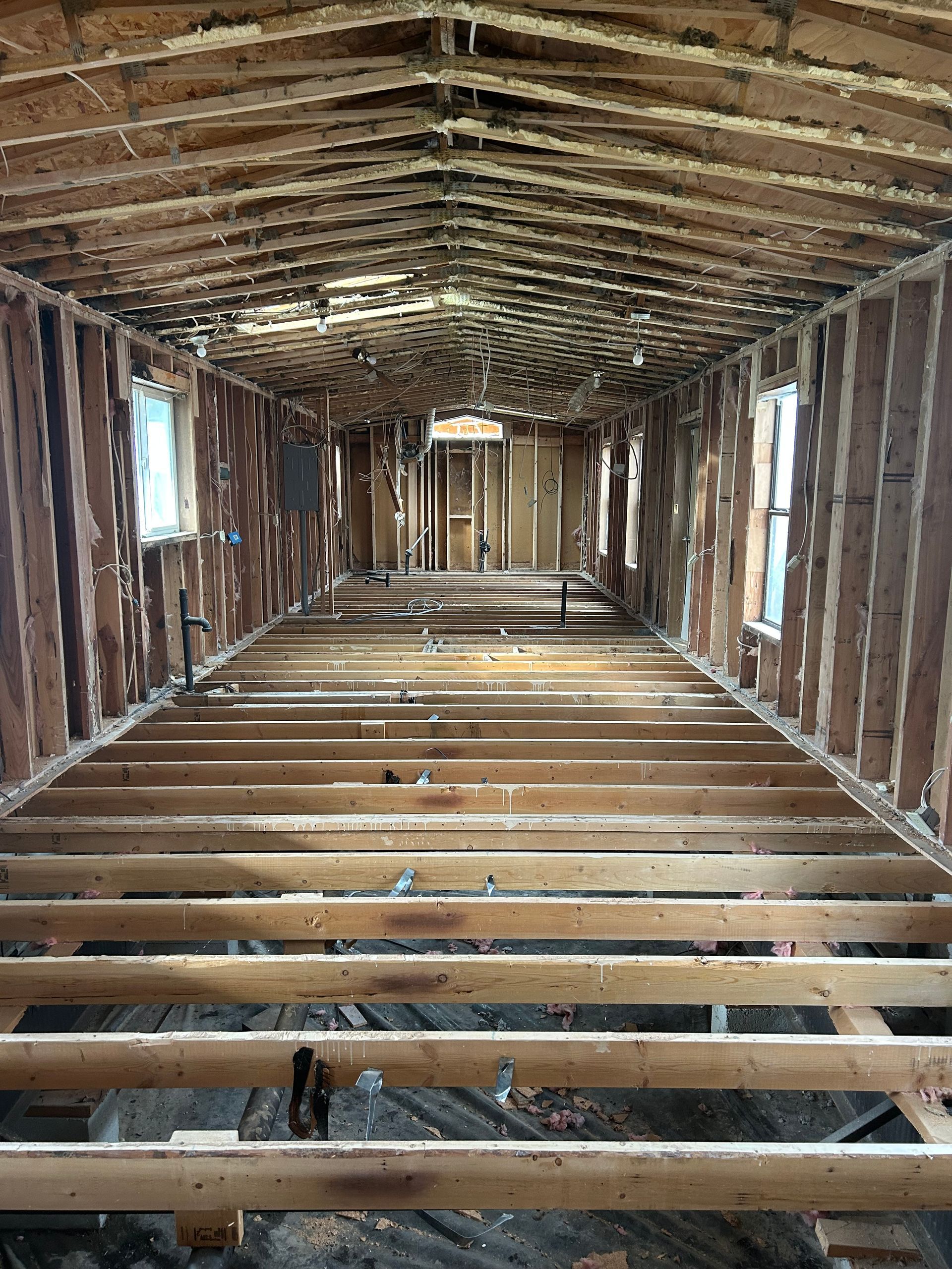 Two men are standing next to a trailer with a large piece of wood on it.
