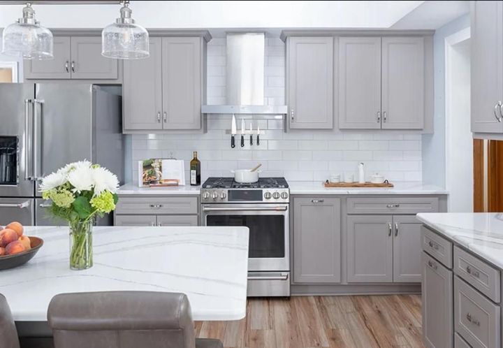 A kitchen with gray cabinets and stainless steel appliances
