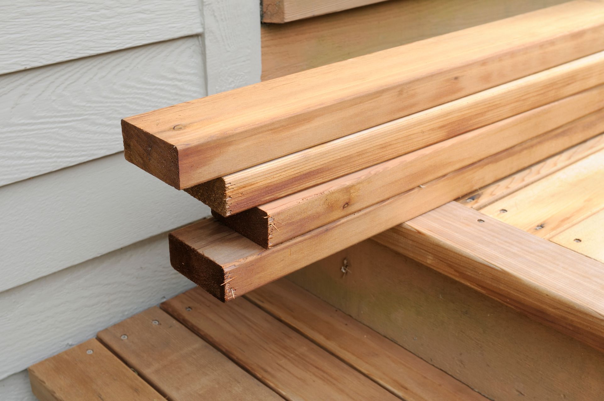 A stack of wooden boards sitting on top of a wooden deck.
